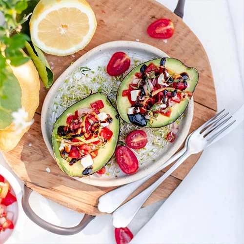 Garnie avec avocat, tomate cherry et olives violettes